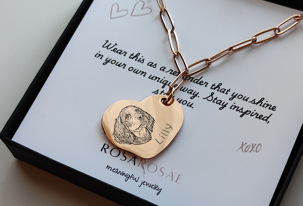 Rose Gold necklace with heart-shaped pendant on a card with text and branding